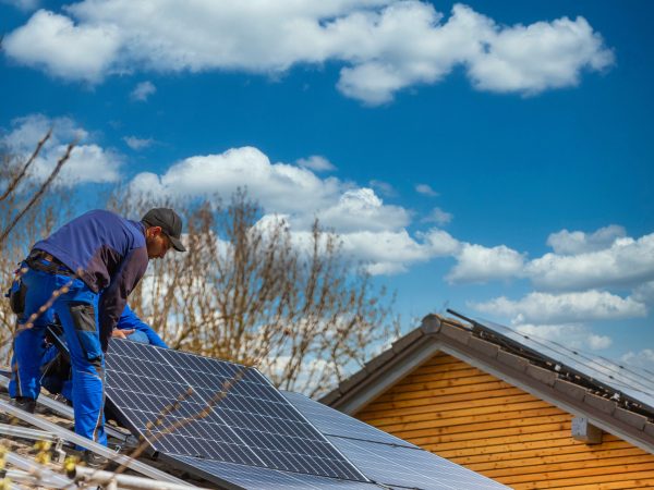 Installing solar photovoltaic panel system. Solar panel technician installing solar panels on roof. Alternative energy ecological concept.